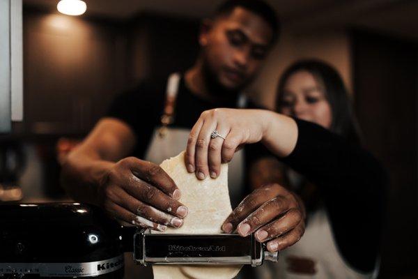 In home engagement photoshoot. Couple making homemade pasta together.