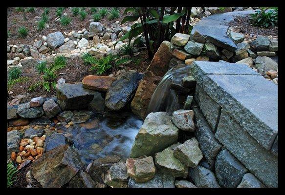 This beautiful waterfall incorporates a natural yet exotic setting in the backyard. Tallahassee water features.