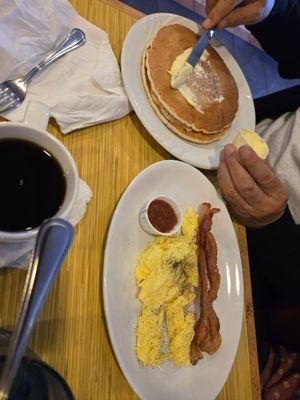 Eggs, bacon and pancakes, salsa on the side.