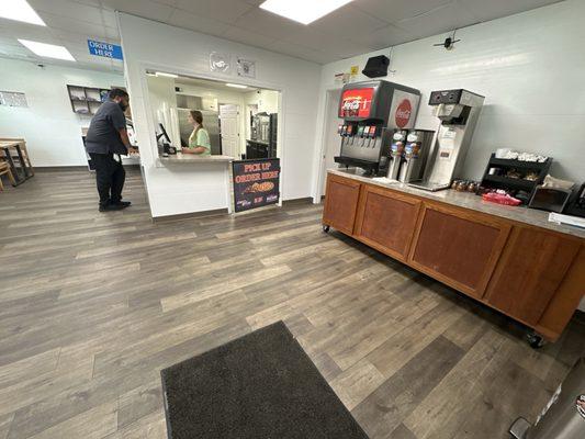 Inside area with a few tables and soda fountain