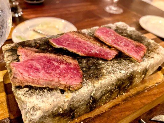 Sliced Wagyu strip cooked on a 500-degree salt block