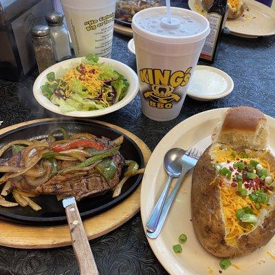 Grilled steak with veggies, baked potato and salad