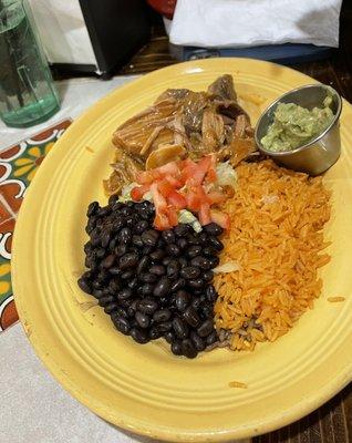 Tender and flavorful Carnitas with black beans, rice and guacamole.