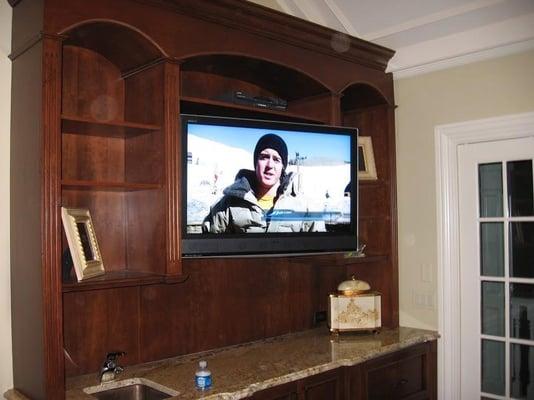 This flat panel TV was mounted above a wet bar inside a custom built cabinet. It is able to swivel to the side for viewing an...