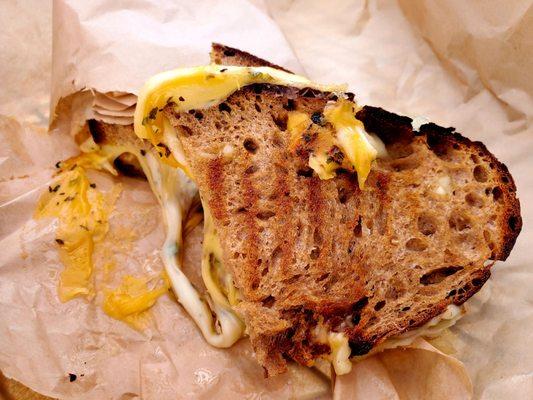 Grilled four-cheese sandwhich, with herbs. Delicious baked bread.