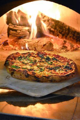 A Cime Di Rapa pie fresh and hot out of the oven! 
 Cime Di Rapa: Italian Sausage, Broccoli Rabe, Parmigiano Reggiano and Red Pepper Flakes