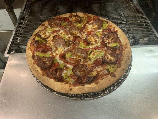 Aviero Signature Pizza with Andouille sausage, pepperoncini, bacon, roasted red peppers, and cilantro.