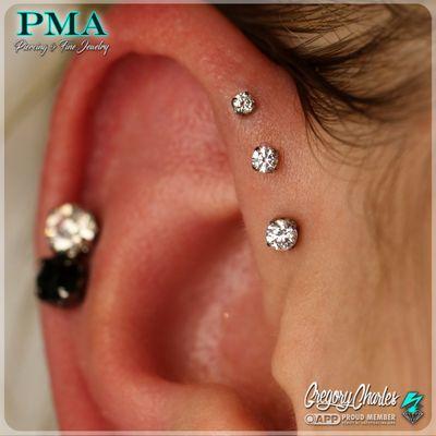 Triple forward helix piercings by Gregory Charles.