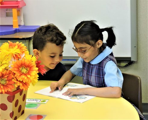 First grader reading to Pre-K3 student.