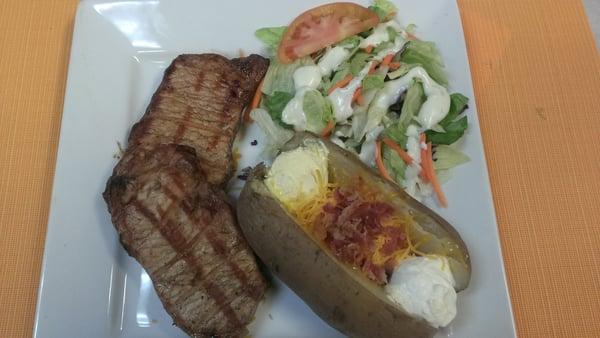 Grilled pork chop entree with loaded baked potato and a la carte salad.