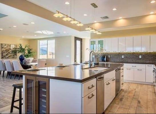 Grand Kitchen Island with additional custom storage cabinets and refrigerator. Caesar stone counter tops.