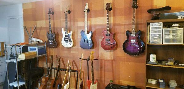 Wall of guitars. 3 of them were made in house