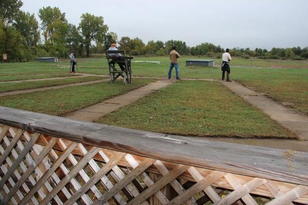 Trap house and 3 shooters with staff member in chair to score and "pull" the clay pigeons.