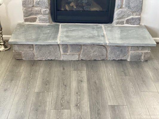 The flooring detail around the stone fireplace