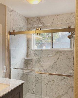 Beautiful Calcutta Marble Shower Transformation, including brushed nickel barn style sliding glass doors.