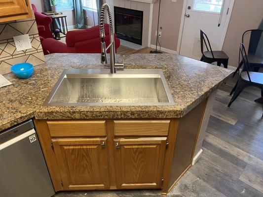 We cut the counter and got that old thing out of there. Installed this large sink and new faucet. Small but amazing update