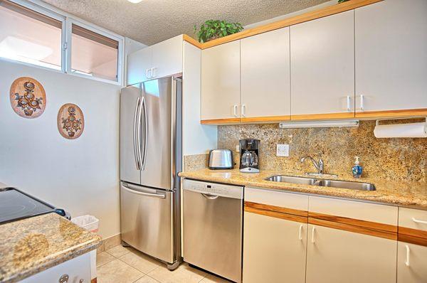 Unit 717 at The Mahana kitchen with granite countertops and stainless steel appliances.