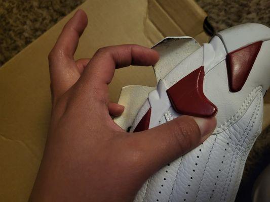 Inner side of right shoe with sole and red side piece falling off.