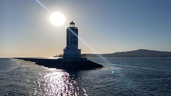 What a gorgeous Light house and look at that sun