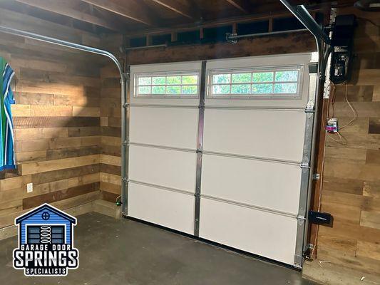 Interior view of newly installed single-car garage door with windows, offering a clear perspective on enhanced interior lighting and style