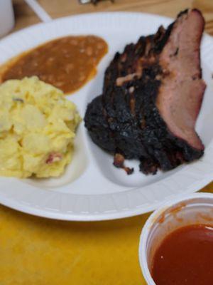 Sliced brisket plate with potato salad and beans.