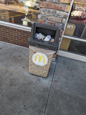 Outside trash bin. Full. Why at 2 PM on a Monday afternoon. Where is the manager? Do they walk the property?