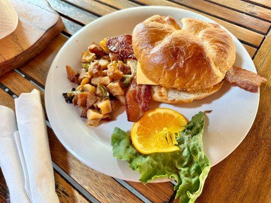 Apple Valley Cafe bacon and cheese croissant with diced breakfast potatoes