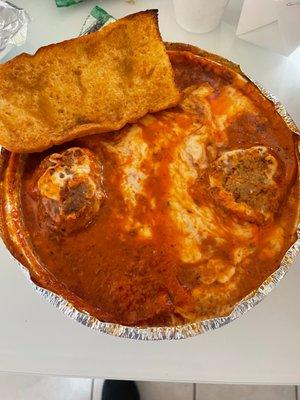 Lasagna with meatballs and garlic bread.