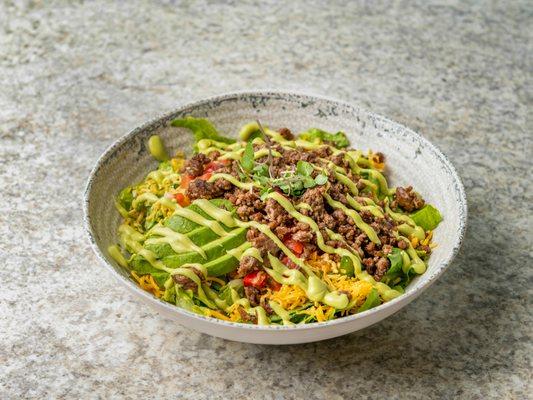 Taco Salad with Chili Campana salsa, cheddar cheese, grass-fed beef and avocado slices finished with Avocado Crema