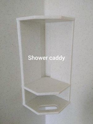 Shower caddy is attached using hot glue and a construction adhesive.  The joints are sealed with caulk.