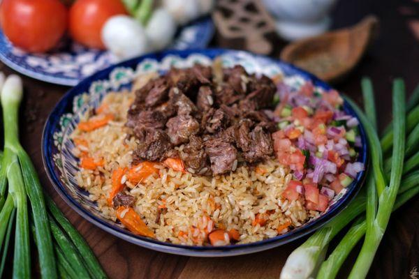 Beef rice Pilaf-Tender chunks of meat, fluffy rice, carrots, onions and cumin cooked in a seasoned broth. Served with salad.