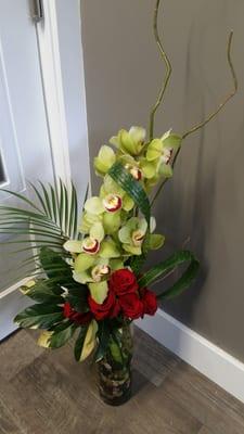 Gorgeous tropical flowers and foliages pair beautifully with classic red roses!