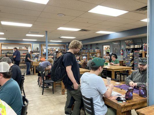 People finishing up round 1 for their MTG Duskmourn prerelease event.