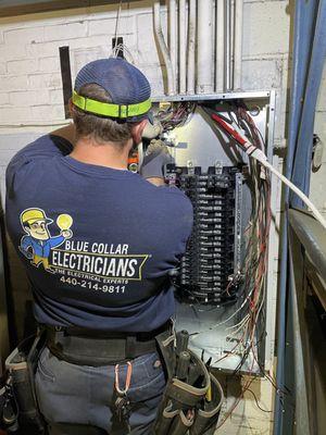 Blue Collar Electrician wiring panel at commercial building