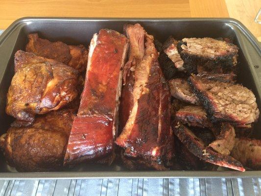 Chicken thighs, ribs and sliced beef brisket in a pan to stay warm in the oven.