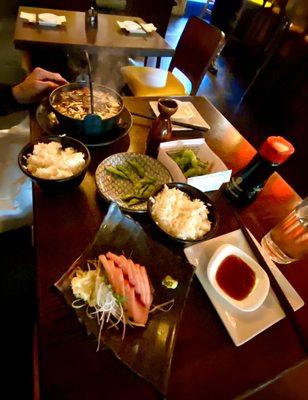 Awesome Japanese meal, with sukiyaki in the background (hot pot beef, noodles, veggies, tofu)