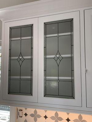 Classic design decorative glass inserts in white cabinet doors using frosted glass in the background to add privacy and glass bevel cluster