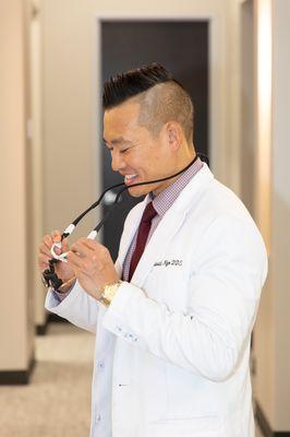 Dr. David Ngo getting ready to put on his dental loupes