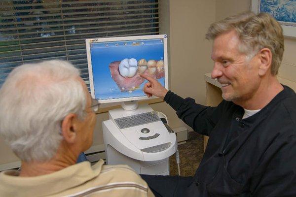 Dr. Engan Showing a patient how he makes his Cerec Crown.