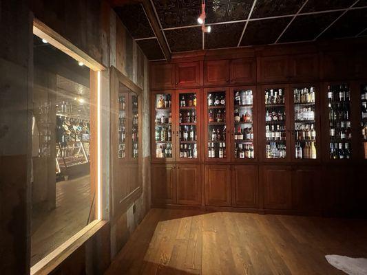 Window looking out to the store, next to the selection of liquor