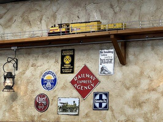 Train riding around room with railroad memorabilia.