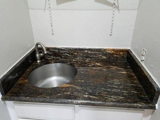 Granite w/ round undermount sink. 2x size i wanted,doesn't take a small drain size. This is a kitchen prep sink. Takes disposal size drains