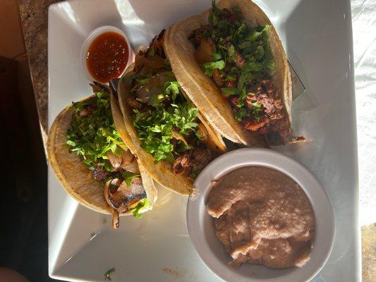 Tacos with steak and chorizo and side of refried beans.