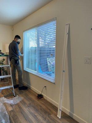 Jorge doing the horizontal blinds in living room.