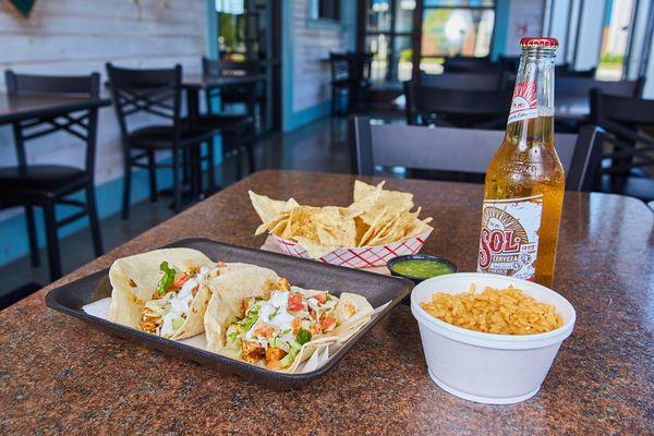 ancho chili chicken tacos with chips, side of rice, and drink