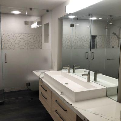 Modern master bathroom with trough sink and etched glass partition