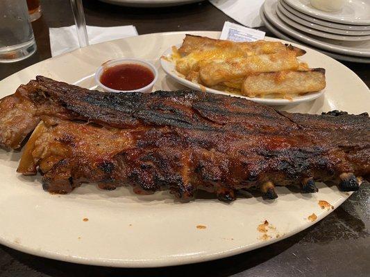 Full rack of ribs and fries with cheese.