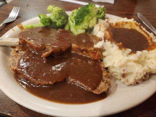 Meatloaf, mashed potatoes gravy and steamed broccoli.