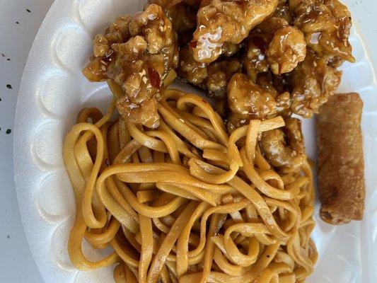 Spicy sesame chicken with lo mein and an egg roll.