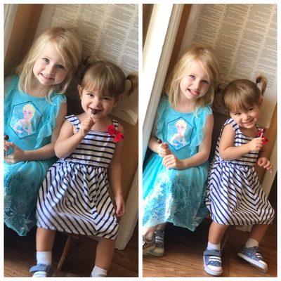 Happy little sisters having a Lilly pop after their haircut